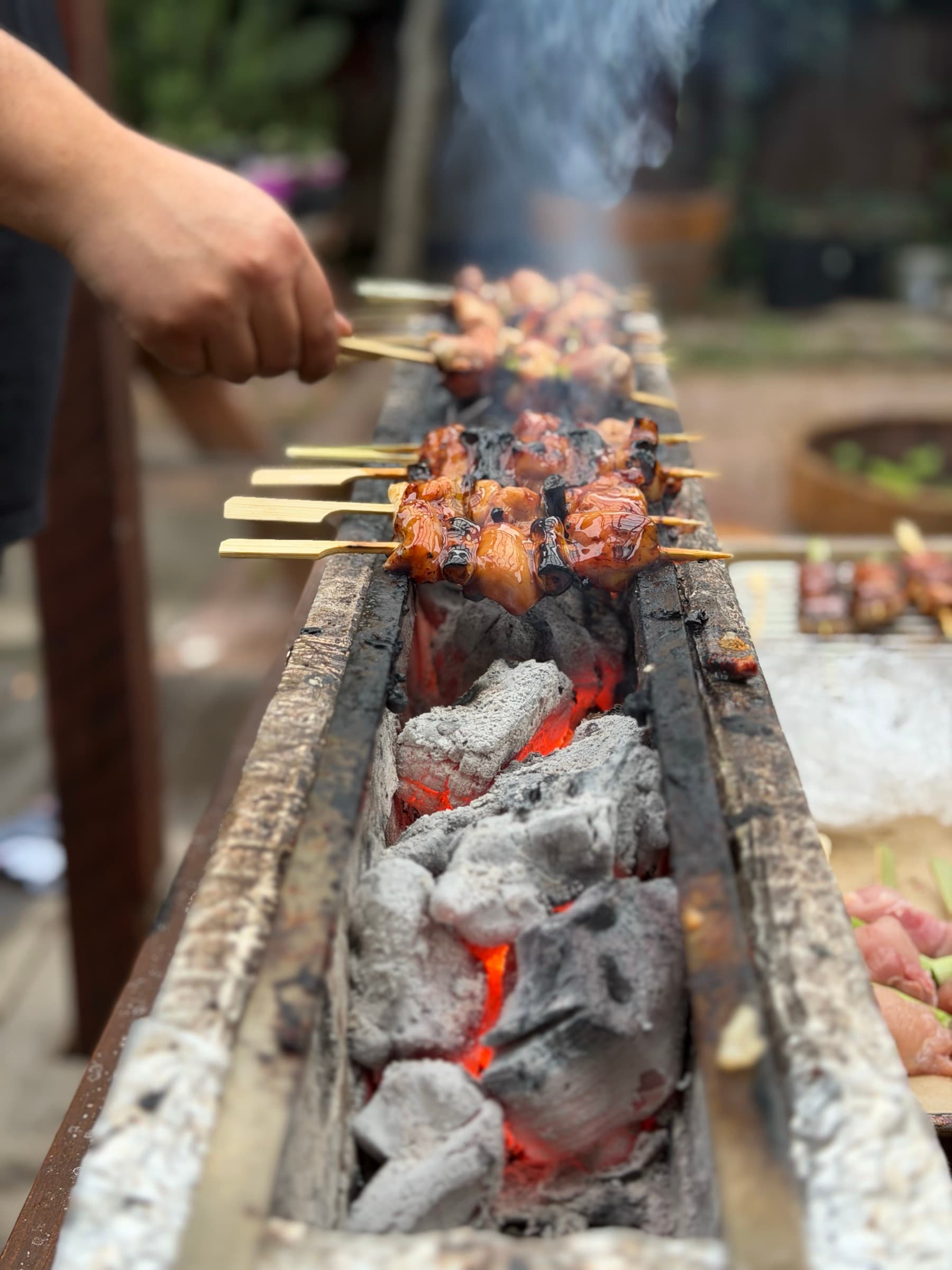 Glazed chicken skewers over glowing binchotan charcoal