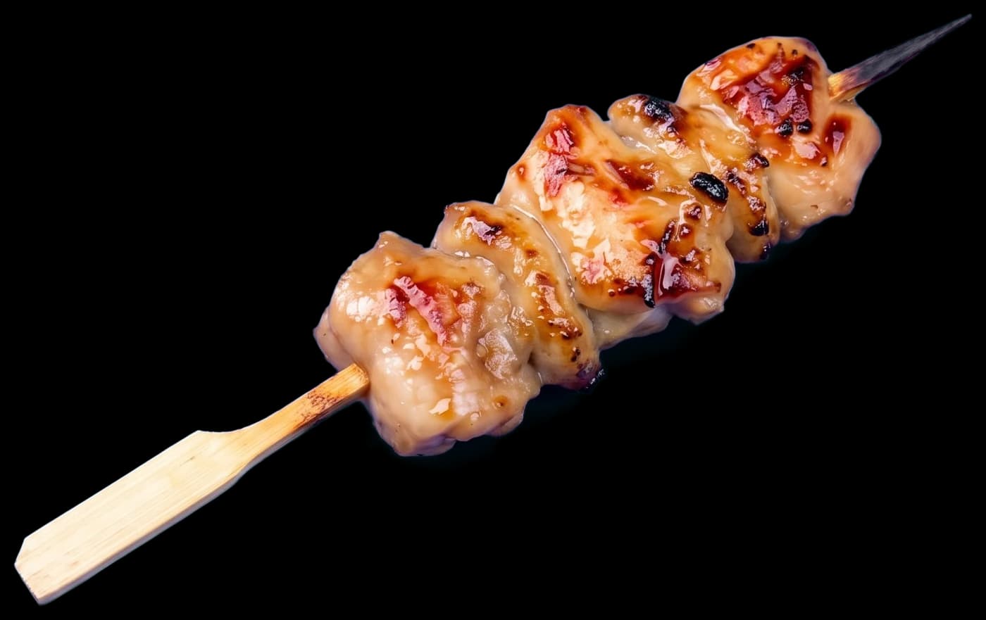 A momo skewer: pieces of chicken thigh grilled with tare, charred at the edges