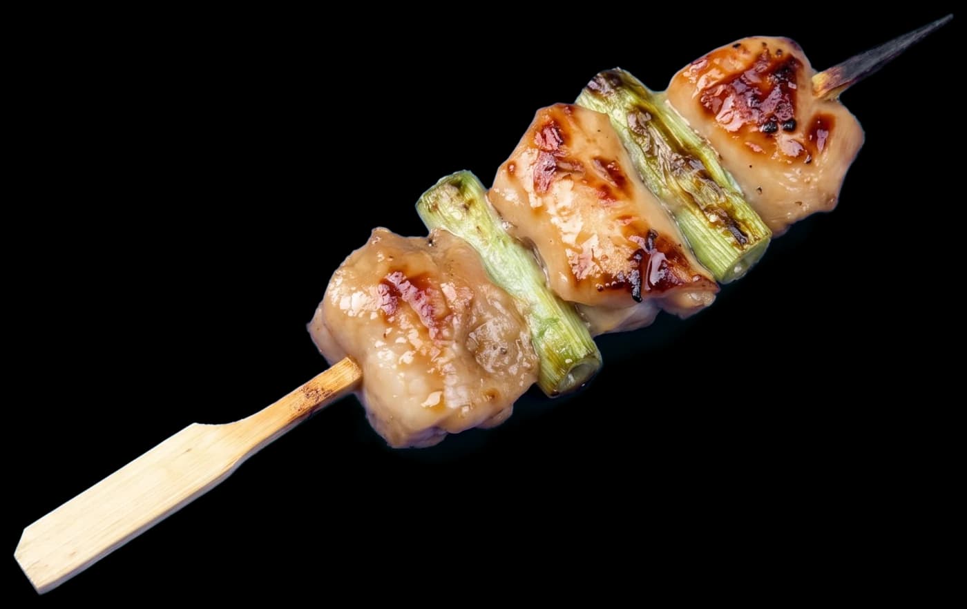 A negima skewer: grilled chicken thigh and green onion, glazed with tare