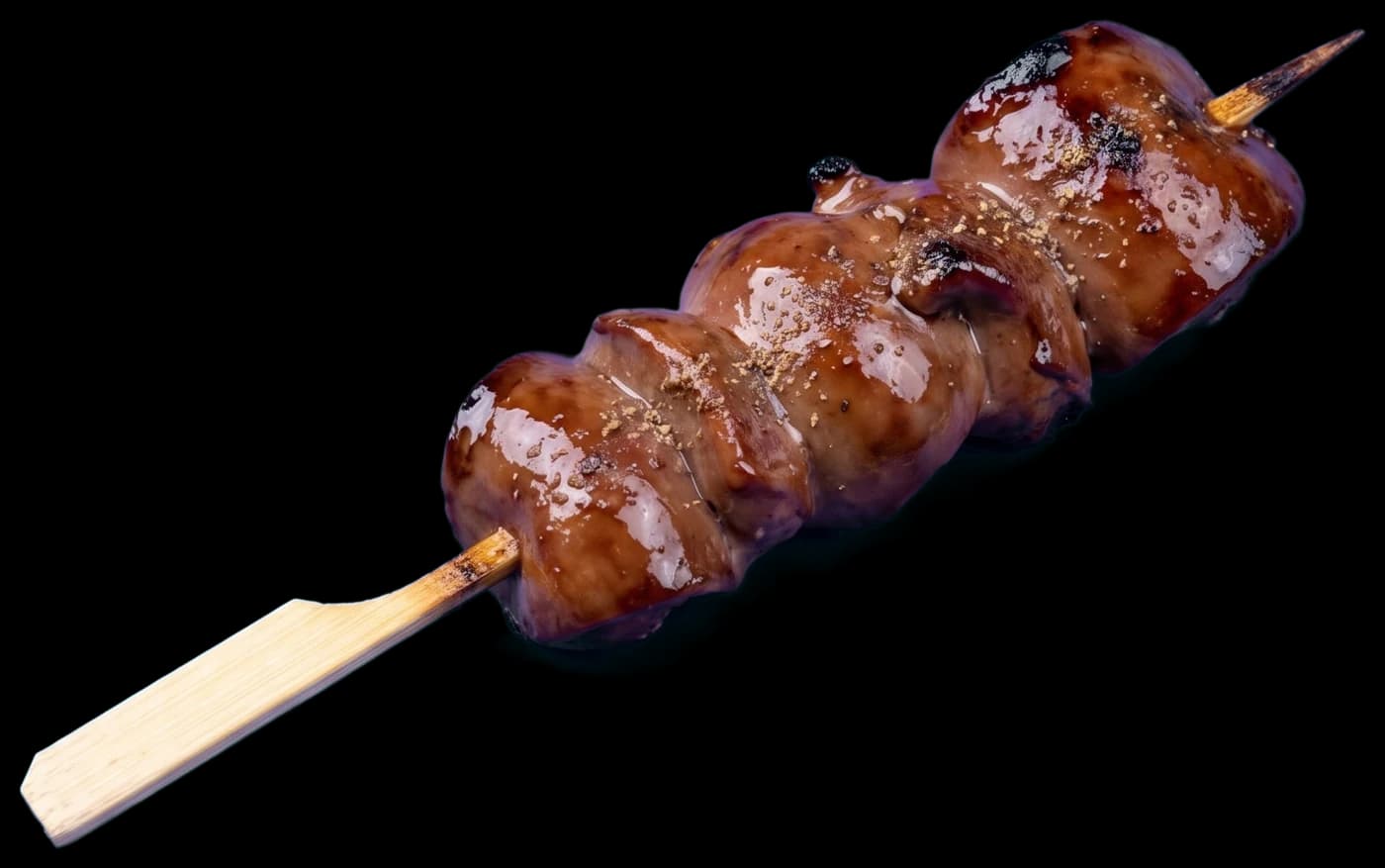 A reba skewer: pieces of chicken liver glazed dark with tare and dusted with sansho