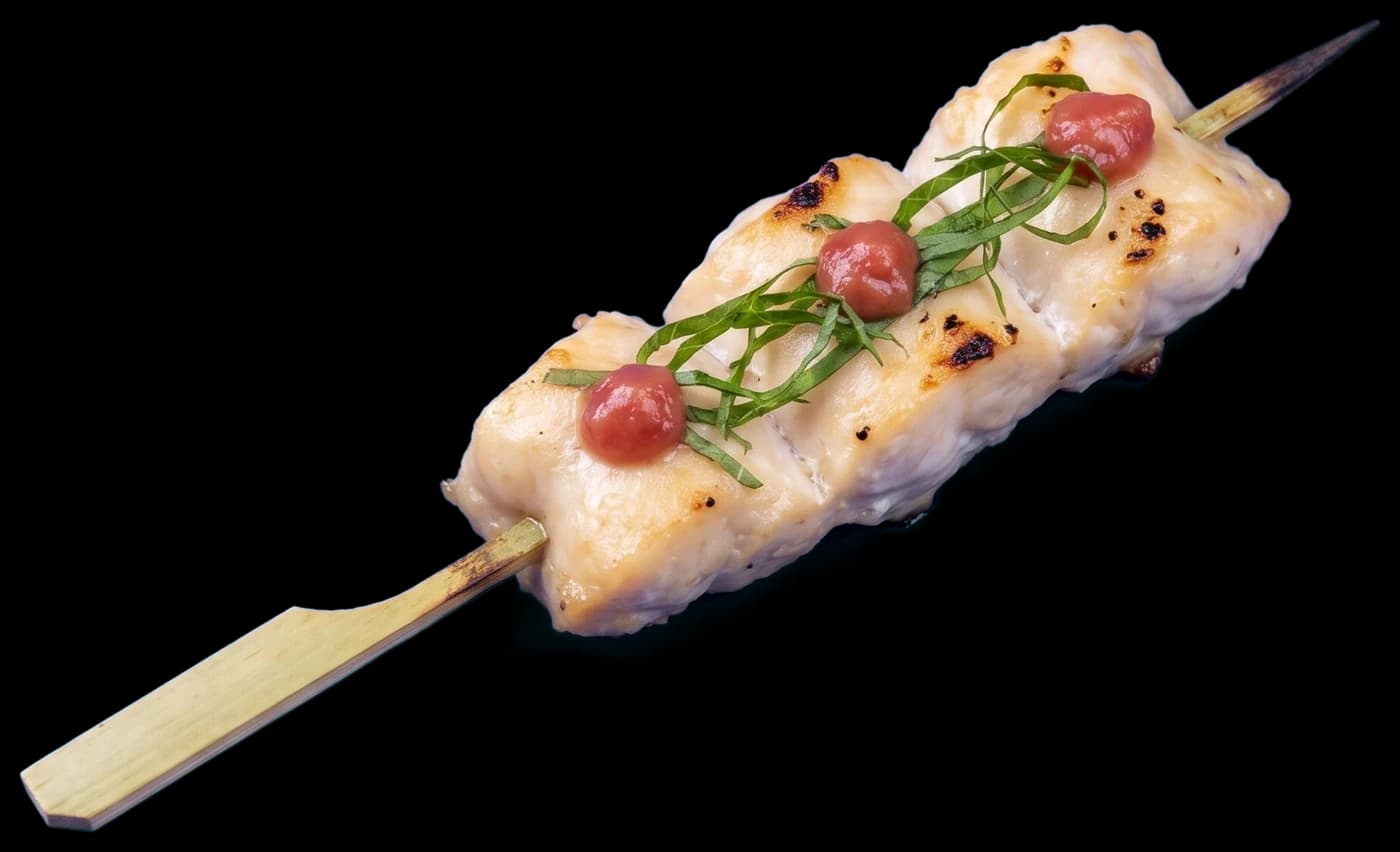 A sasami skewer: salt-grilled chicken tenderloin topped with dabs of ume and ribbons of shiso