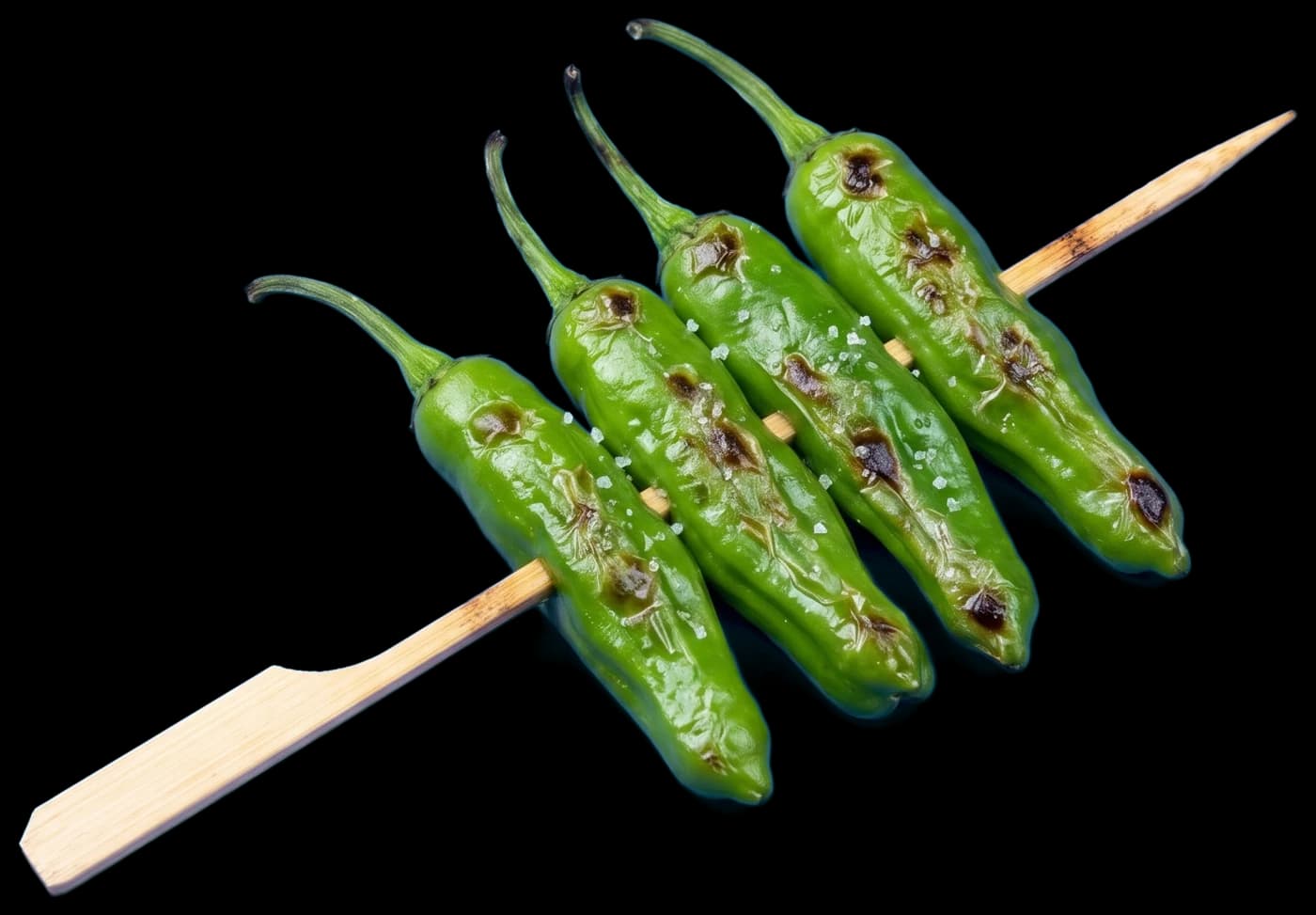 A shishito skewer: four whole shishito peppers, blistered and salted